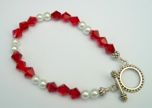 Antiqued silver finish bracelet with ruby glass and white pearl